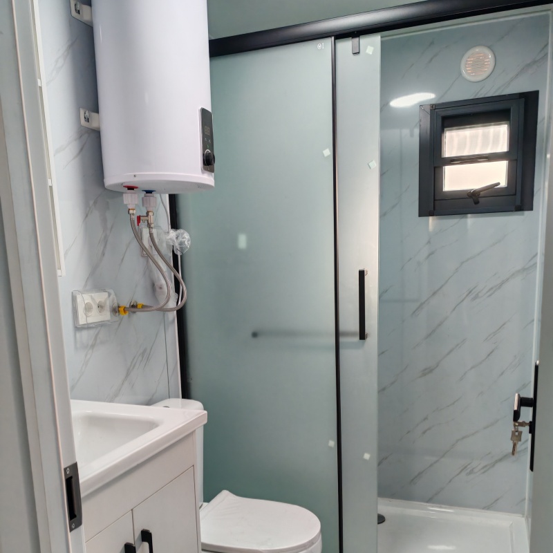Interior view of a bathroom in an expandable container house featuring modern amenities such as a shower, toilet, sink, and water heater