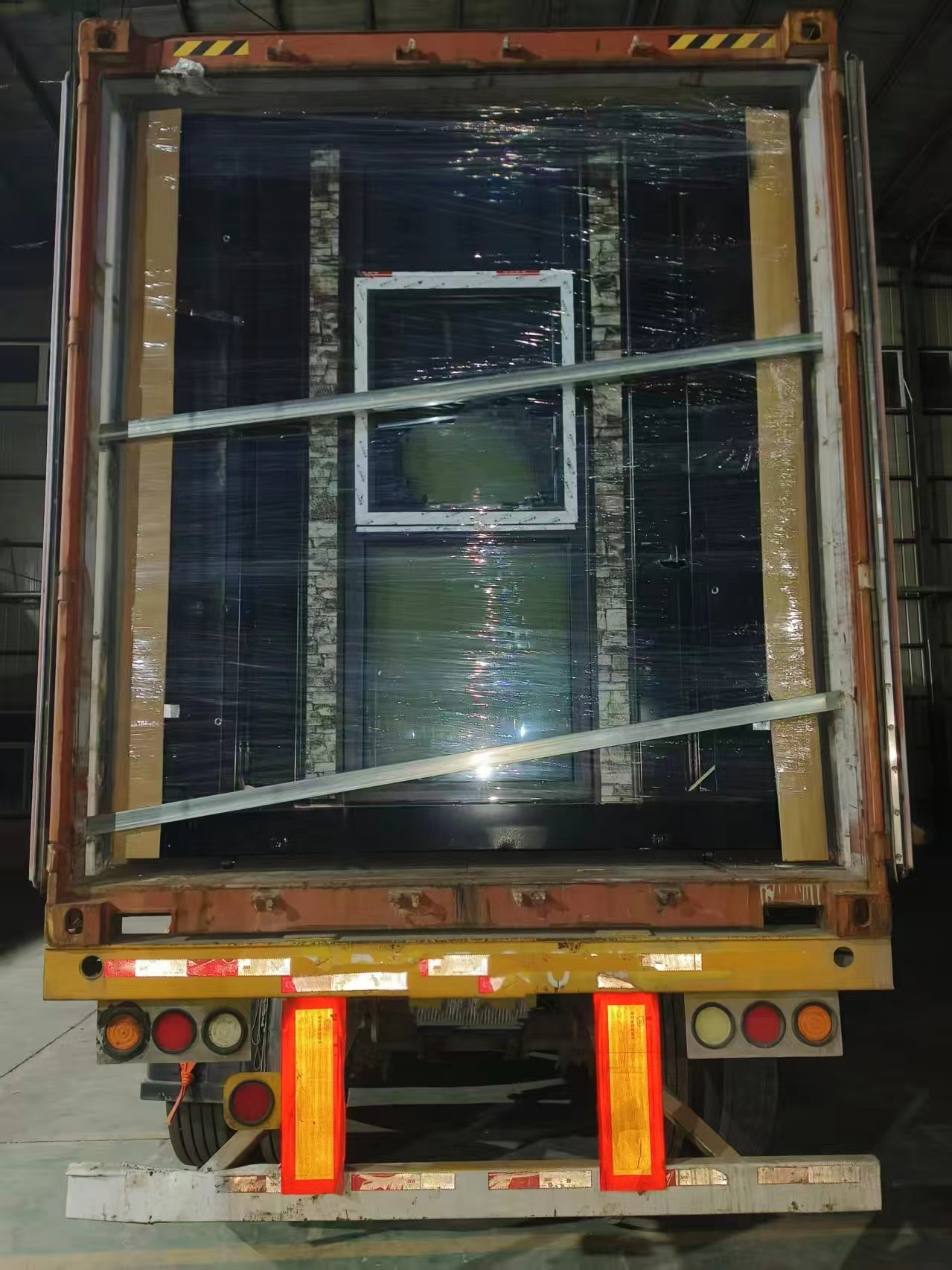 Rear loading view of transport container house with reinforced steel doors and secure locking bars, produced by China container house manufacturing factory for bulk export, overseas transportation, and modular housing projects.