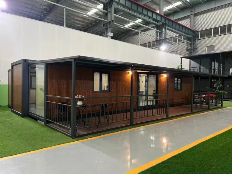 A completed expandable container house project featuring a premium wood-grain exterior finish, a large integrated front porch with black steel railings, and sliding glass doors.